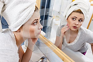 Woman looking at her reflection in mirror