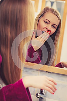 Woman looking at her reflection in mirror