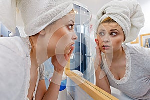 Woman looking at her reflection in mirror