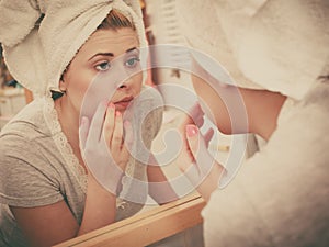 Woman looking at her reflection in mirror