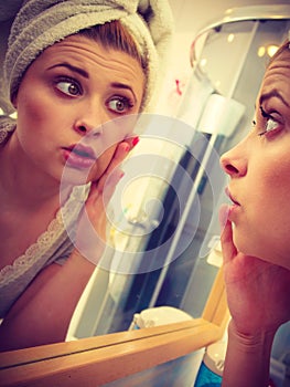 Woman looking at her reflection in mirror