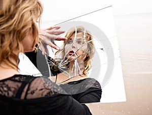 Woman looking at herself in broken mirror