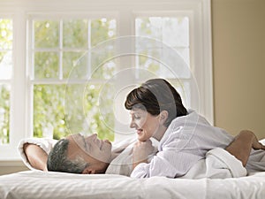 Woman Looking At Husband While Lying In Bed