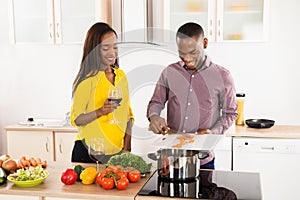 Woman Looking At Husband Preparing Food