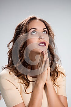 Woman is looking imploring over gray background