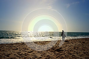 A woman looking at infinite horizon on seashore