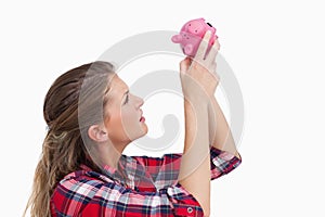 Woman looking inside a piggy bank