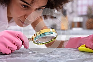 Woman Looking At Kitchen Counter With Magnifying Glass