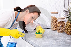 Woman Looking At Kitchen Counter With Magnifying Glass