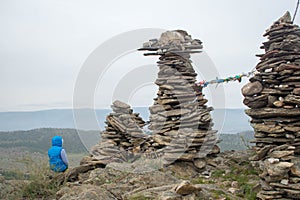 Woman looking at lake Baikal from top of the hillock dedicated to a local Tutelary deity