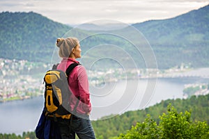 Woman looking at the lake from the edge of the cliff