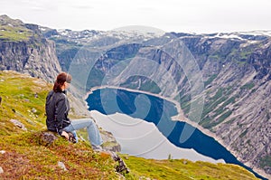 Woman looking at the lake in the mountains, Norway. Path to Trol