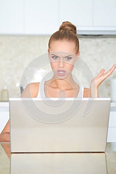 Woman looking at laptop in horror