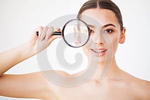 Woman Looking Through Magnifier And Smiling Close Up
