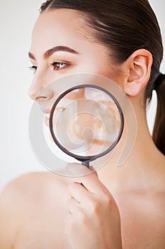 Woman Looking Through Magnifier And Smiling Close Up