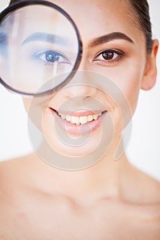 Woman Looking Through Magnifier And Smiling Close Up