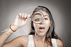 Woman looking through magnifying glass