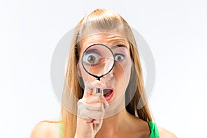 Woman looking through magnifying glass