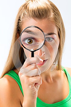 Woman looking through magnifying glass