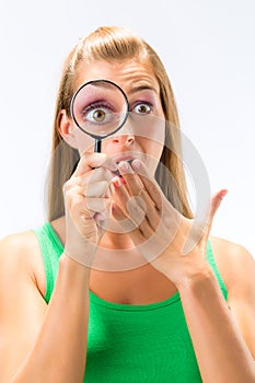 Woman looking through magnifying glass