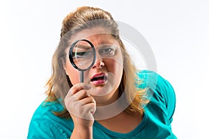 Woman looking through magnifying glass