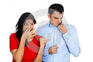 Woman looking at man closing, covering nose