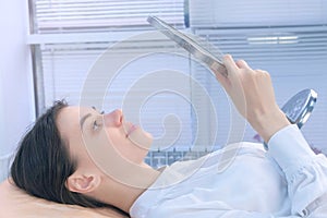 Woman is looking at mirror after beauty procedure of eyelash lifting laminating.