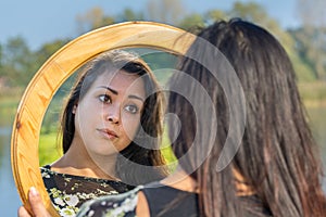 Woman looking at mirror in nature