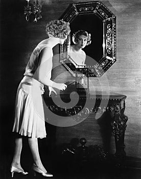 Woman looking into a mirror about to ring a bell