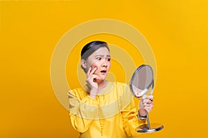 Woman looking in the mirror and worried the wrinkles