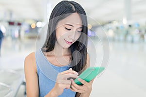 Woman looking at mobile phone in the airport
