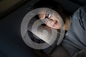 Woman looking on mobile phone on bed