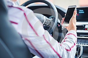 Woman looking at mobile phone while driving a car. Driver using smart phone in car