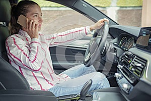 Woman looking at mobile phone while driving a car. Driver using smart phone in car.