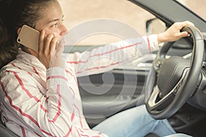 Woman looking at mobile phone while driving a car. Driver using smart phone in car.
