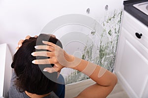 Woman Looking At Mold On Wall