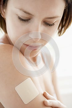 Woman Looking At Nicotine Patch On Arm