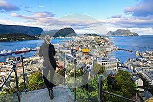 Woman looking out at colorful town of Alesund Norway