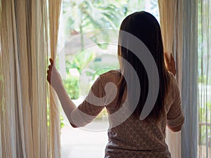 Woman looking out a window, indoors. photo