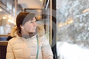 Woman looking out of the window of train during travel on cogwheel railway/rack railway in Alps mountains