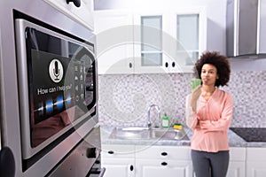 Woman Looking At Oven With Voice Recognition Function