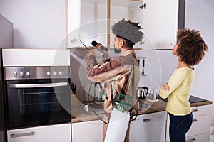 Pest Control Worker Spraying Insecticide On Shelf photo