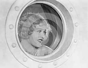 Woman looking through porthole