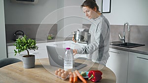 Woman looking recipe online while cooking