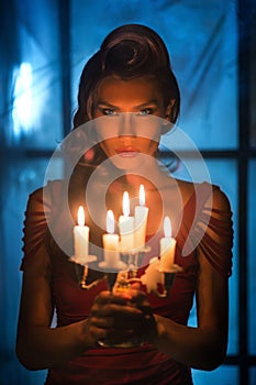 Woman looking on red candles in the fabulous night