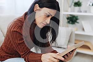 Woman looking sadly at the picture frames in her hands, crying over memories, state of depression and loss of a person