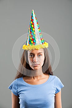 Woman looking with sadness while wearing party hat