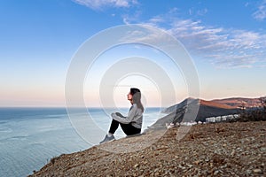 Woman looking on sea in the mountains