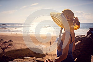 Woman looking at the sea sitting close to the beach