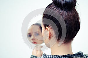 Woman looking at self reflection in mirror